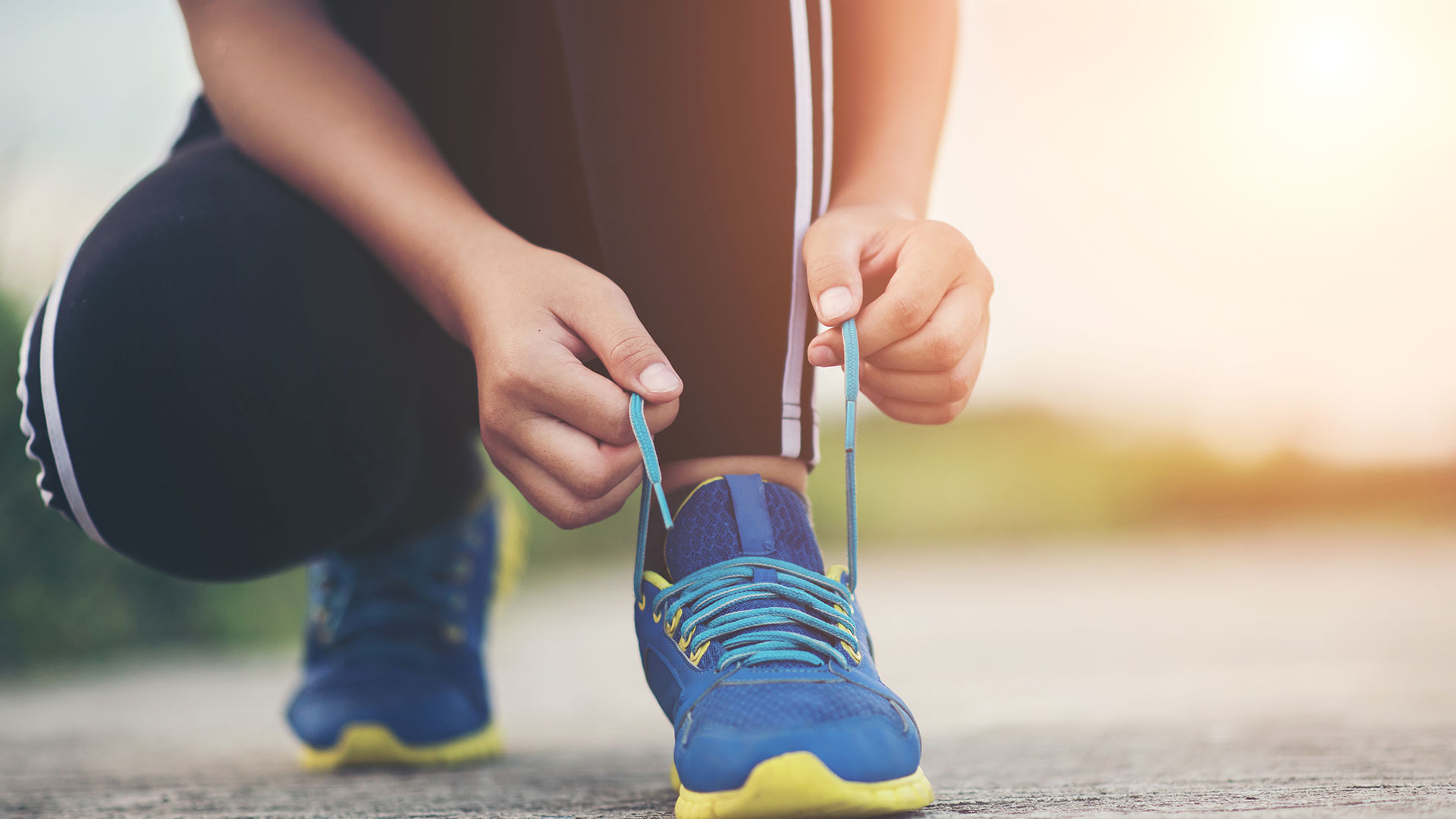Corredora de atletismo atándose los nudos de sus zapatillas