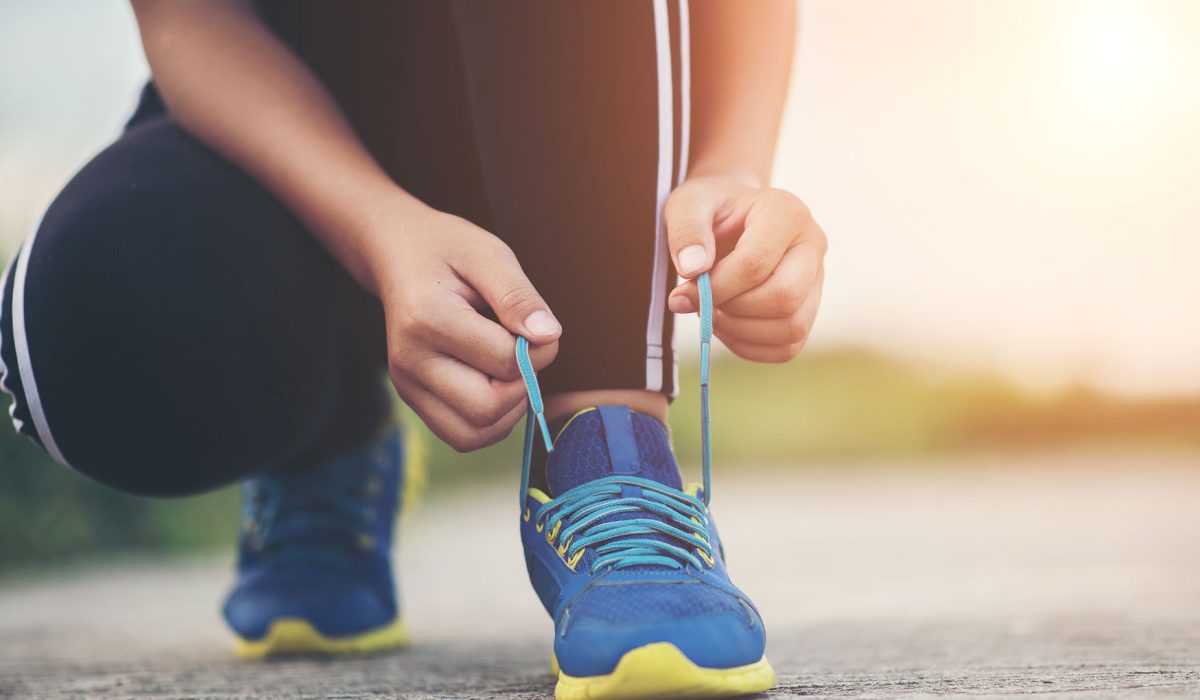 Corredora de atletismo atándose los nudos de sus zapatillas